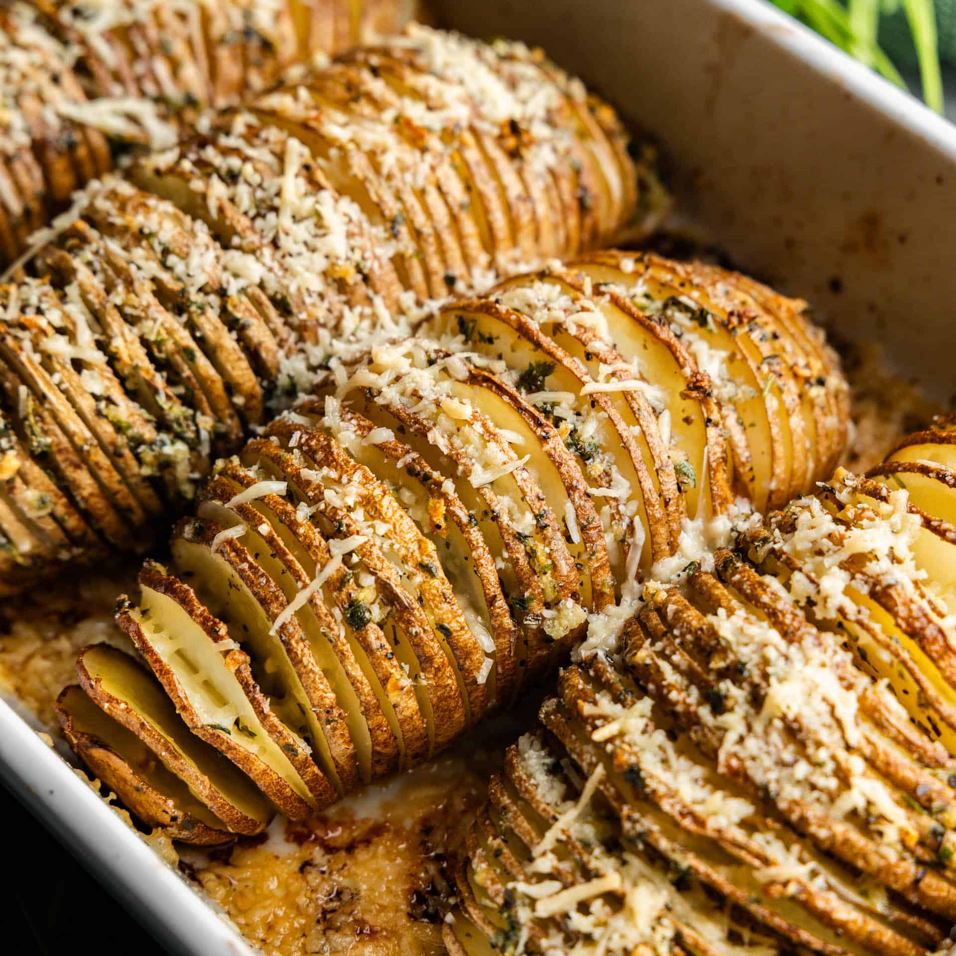 A casserole dish filled with perfectly baked hasselback potatoes ready to serve.