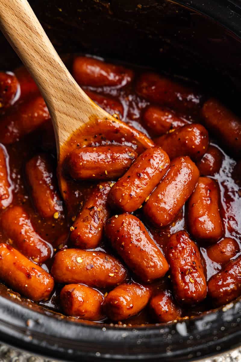 A close up look into a crockpot of lit'l smokies.