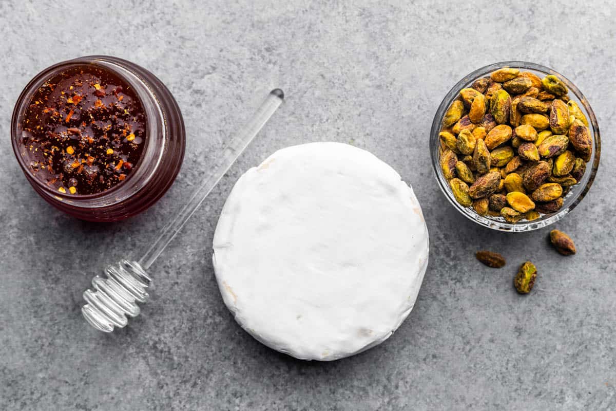 An overhead view of the ingredients needed to make hot honey pistachio baked brie.