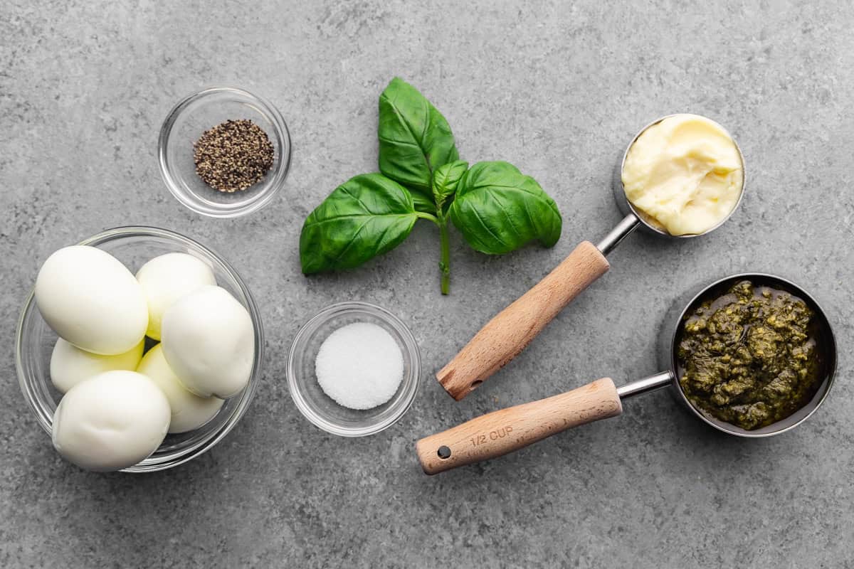 An overhead view of the measured ingredients needed to make pesto deviled eggs.