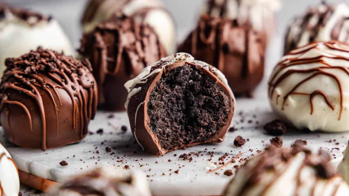 A close-up of Oreo truffles arranged on a table, with one in the front with a bite taken out