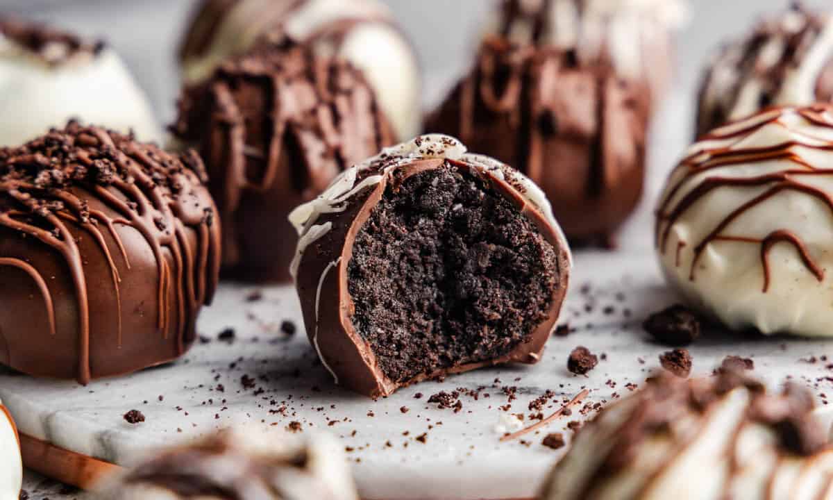 A close-up of Oreo truffles arranged on a table, with one in the front with a bite taken out