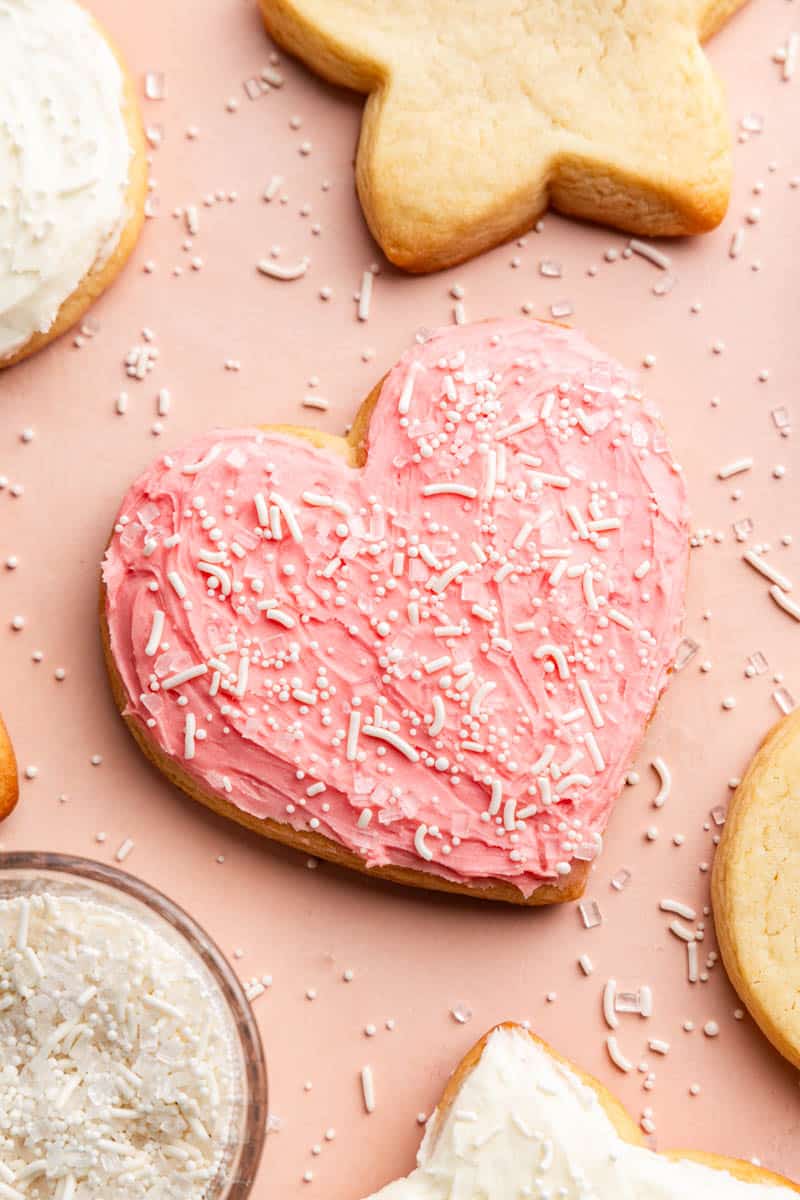 overhead view of a homemade heart shape sugar cookie covered in frosting