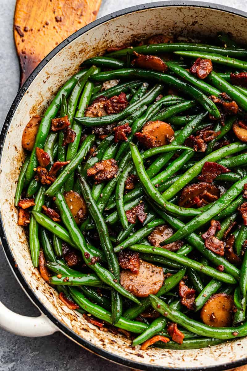 pan full of sauteed green beans with bacon and water chestnuts