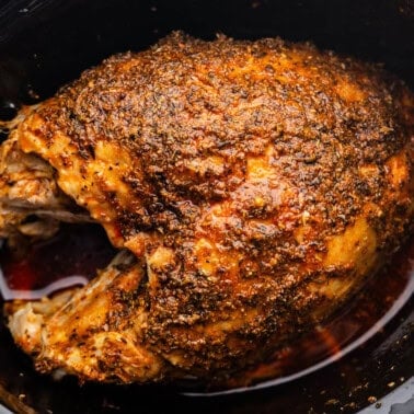 An overhead view of a turkey breast in the crock of a slow cooker.