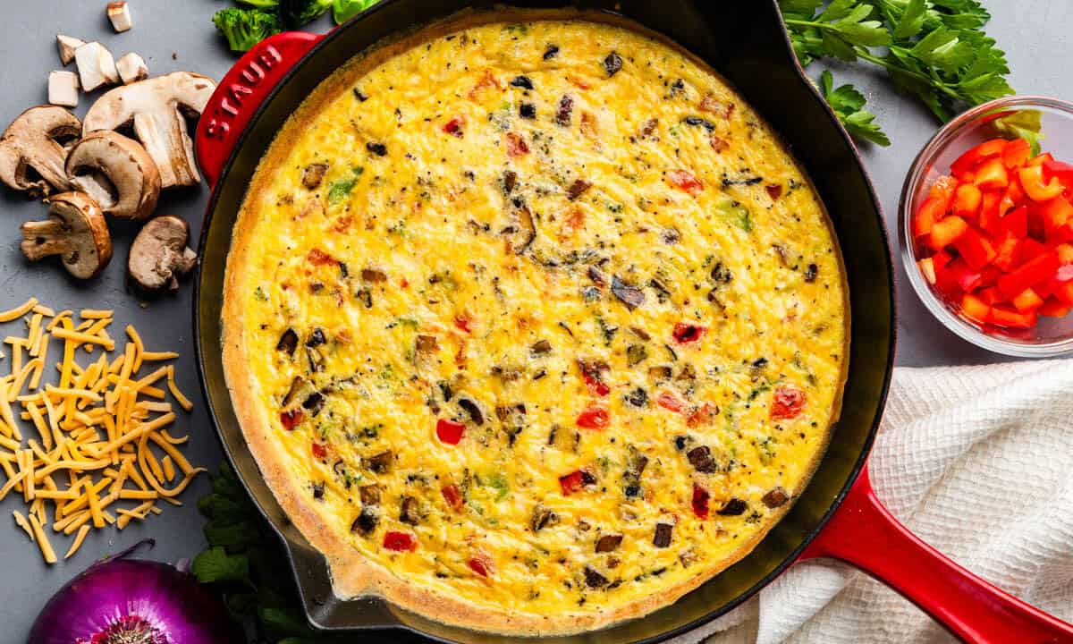 An overhead view of a veggie frittata in a cast iron skillet.