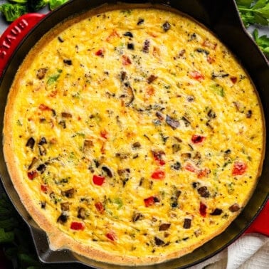 An overhead view of a veggie frittata in a cast iron skillet.