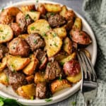 A close up view of a plate of steak bites and potatoes made in the air fryer.