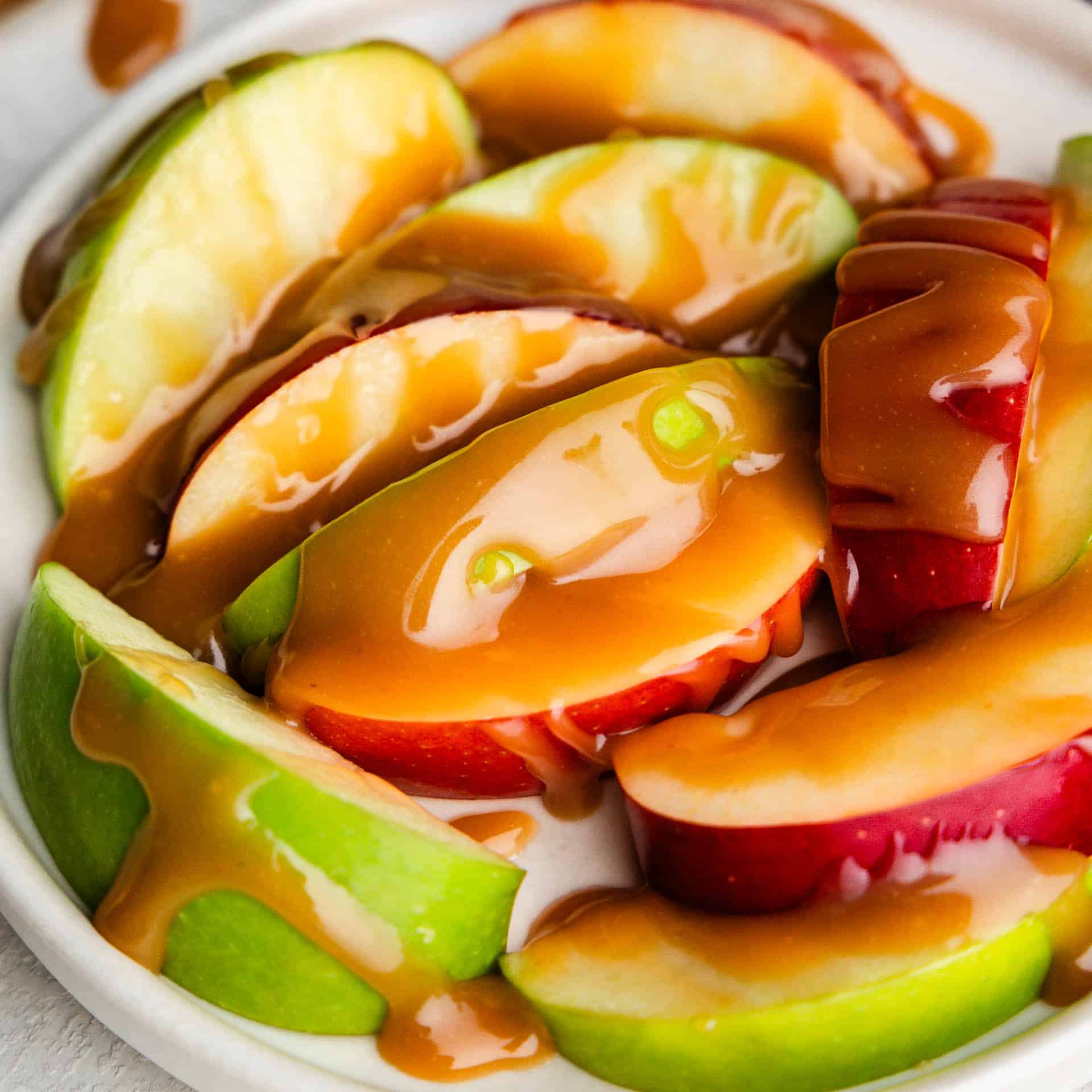 A plate of apples coated with drizzles of apple bourbon caramel sauce.