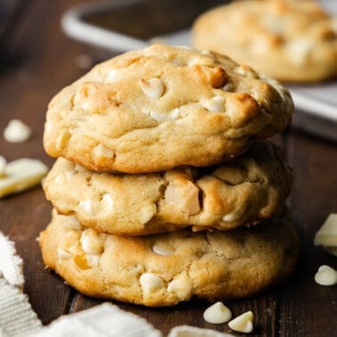 A stack of three white chocolate macadamia nut cookies.