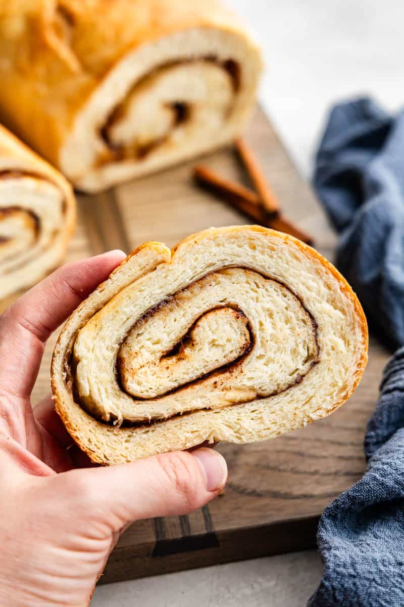 hand holding a slice of cinnamon swirl bread