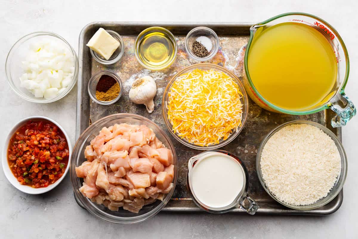 An overhead view of the ingredients needed to make a pot of queso chicken and rice.