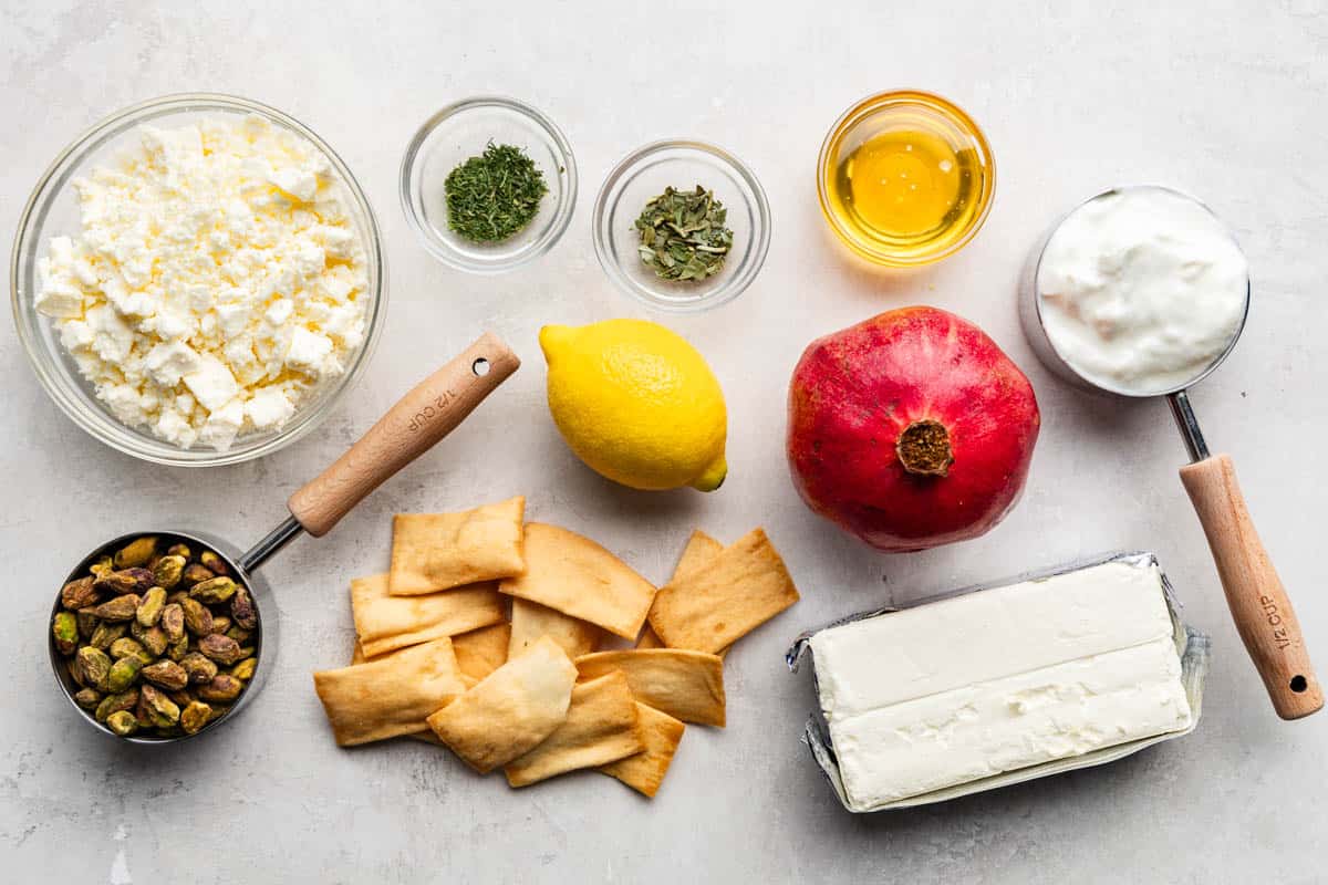 An overhead view of the ingredients needed to make pomegranate pistachio whipped feta dip.