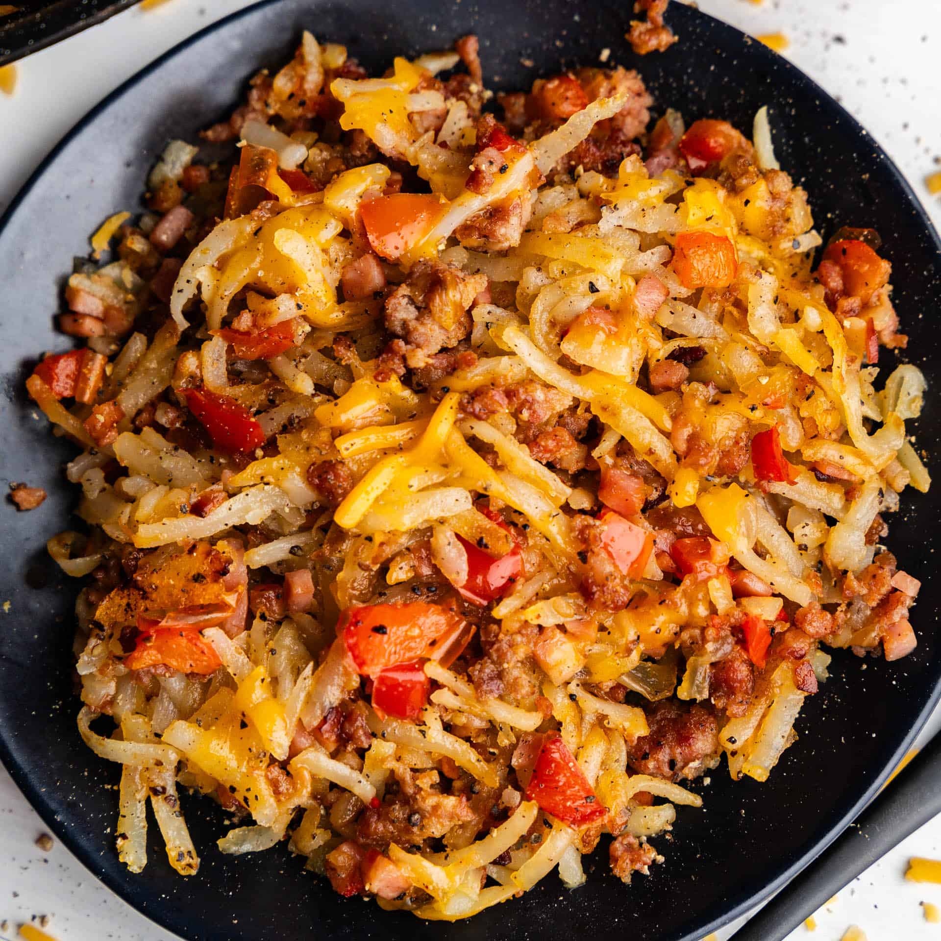 A top view of a plate filled with loaded breakfast hash.