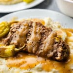 slice of Mississippi Pot Roast Meatloaf on plate with mashed potatoes and gravy