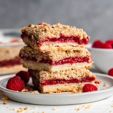 stack of raspberry streusel dessert bars on round plate