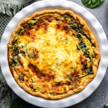 a top view of a whole tuscan quiche in white pan