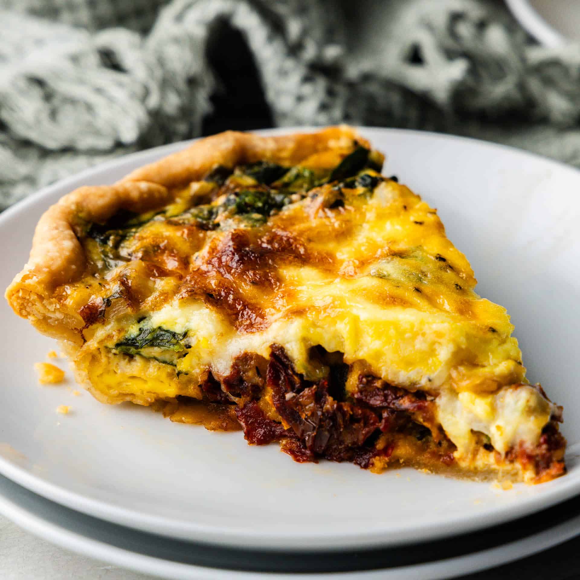 side view of slice of tuscan quiche on a plate