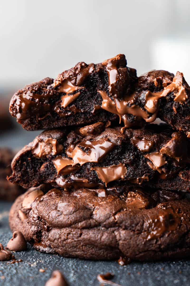 A close up of a stack of 3 ooey gooey chocolate chunk cookies.