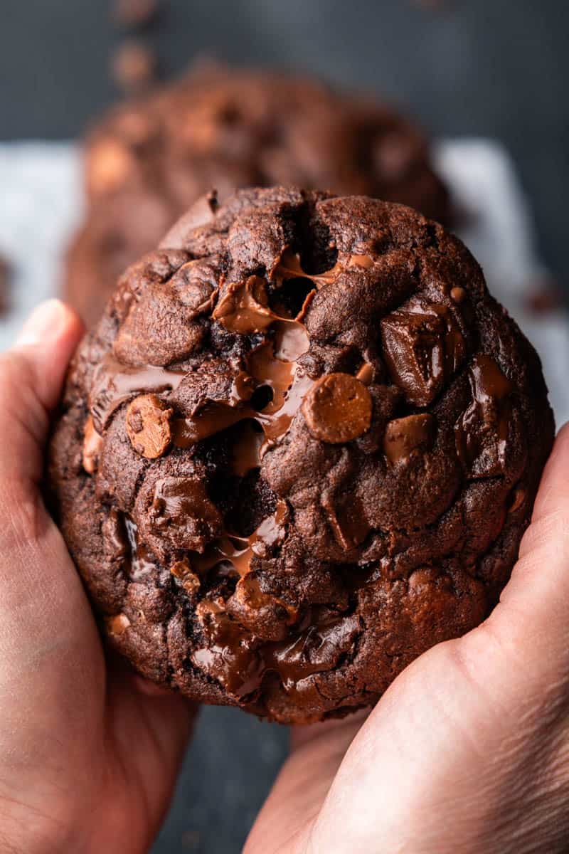 Hands pulling apart a chocolate chunk cookie.