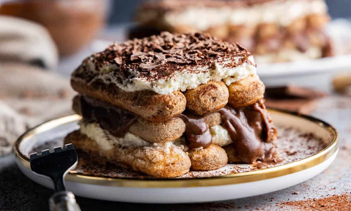 Angled shot of tiramisu slice on a plate with a fork.