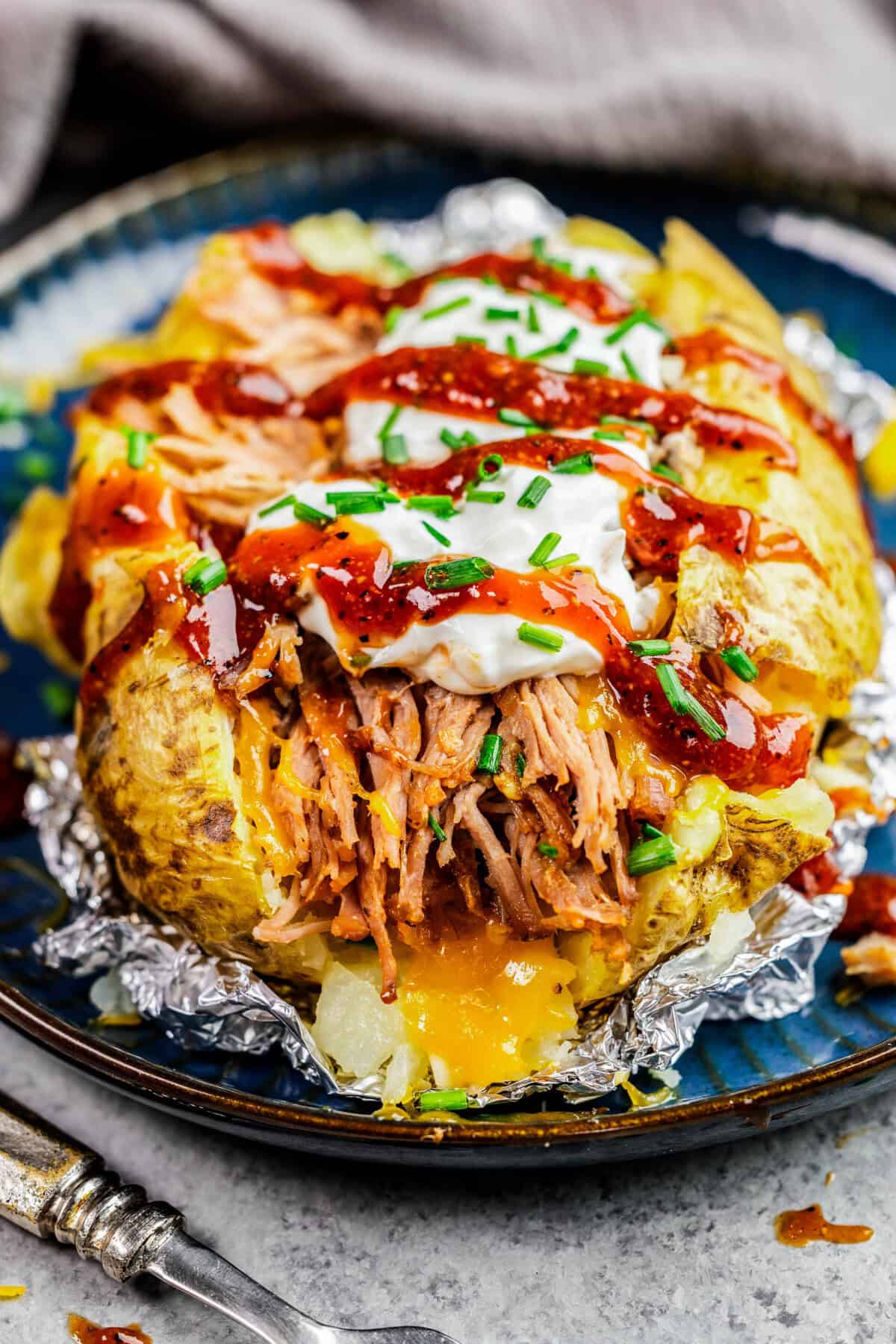 Closeup view of loaded pulled pork potato on a plate.