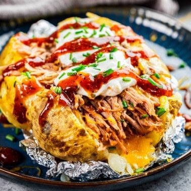 Closeup view of loaded pulled pork potato on a plate.