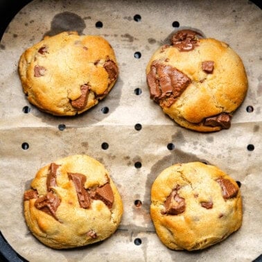 Chocolate chip cookies in air fryer basket.