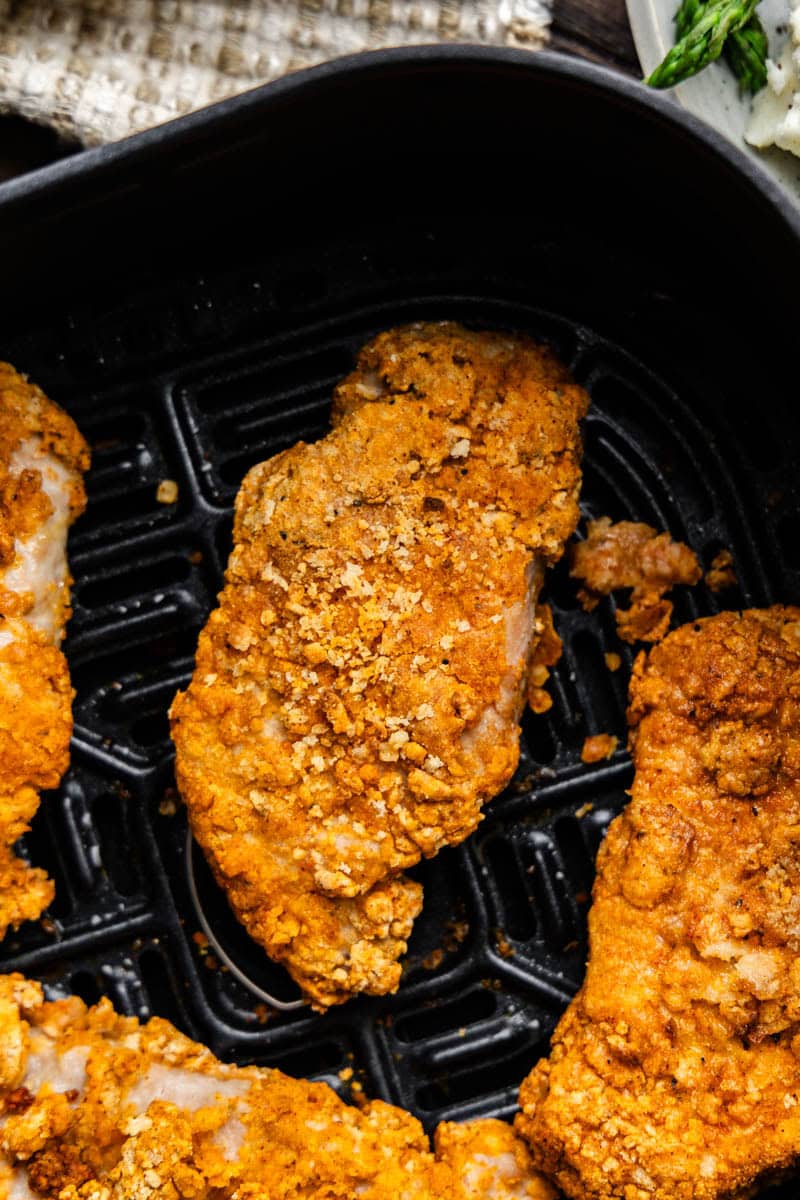 Overhead shot of Air fryer crispy pork chops in air fryer.