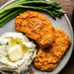 Overhead shot of Air fryer crispy pork chops on a plate with mashed potatoes and asparagus.