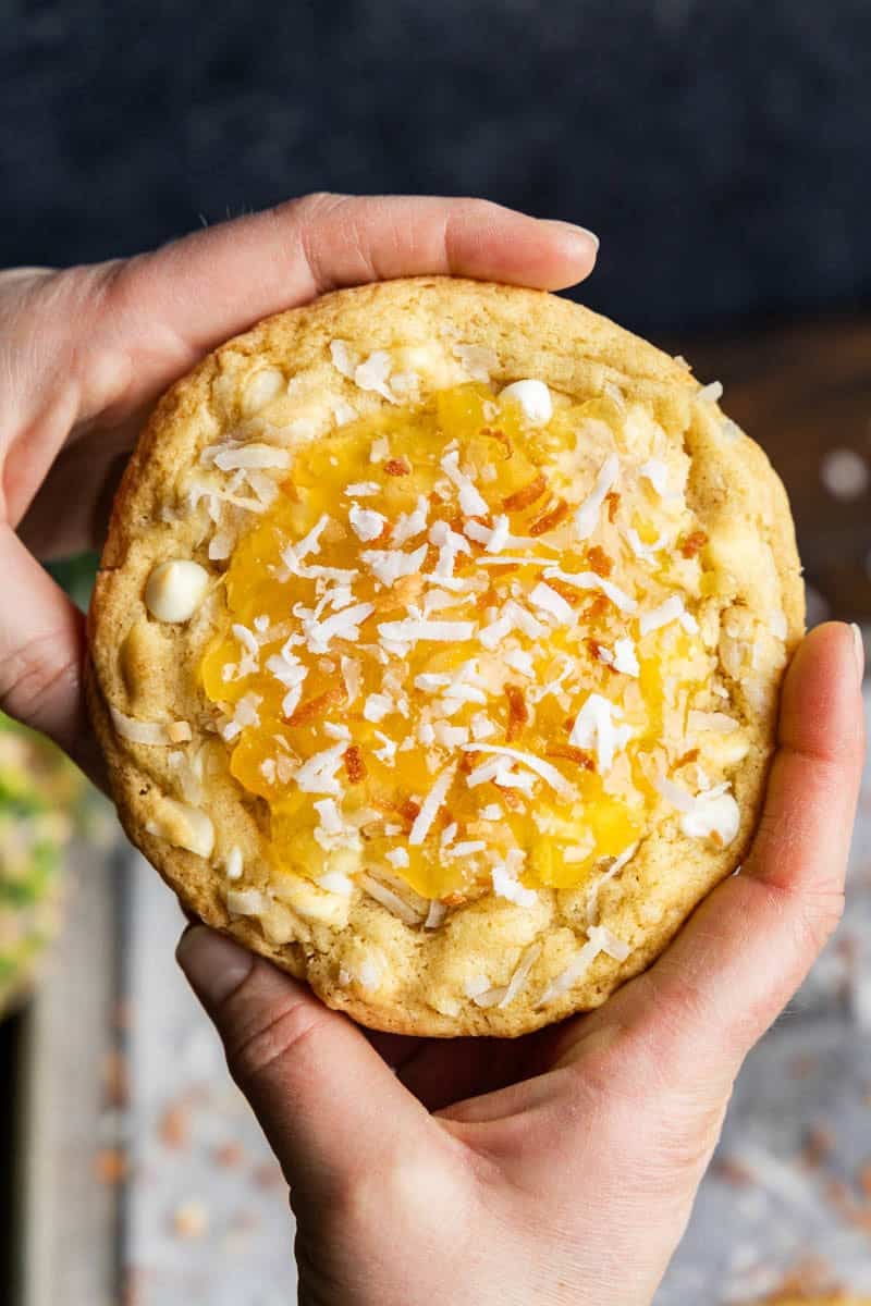 Hands holding Bakery Style Pina Colada Cookie.