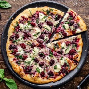 Overhead view of entire Blackberry Basil Ricotta Pizza sliced into pieces.