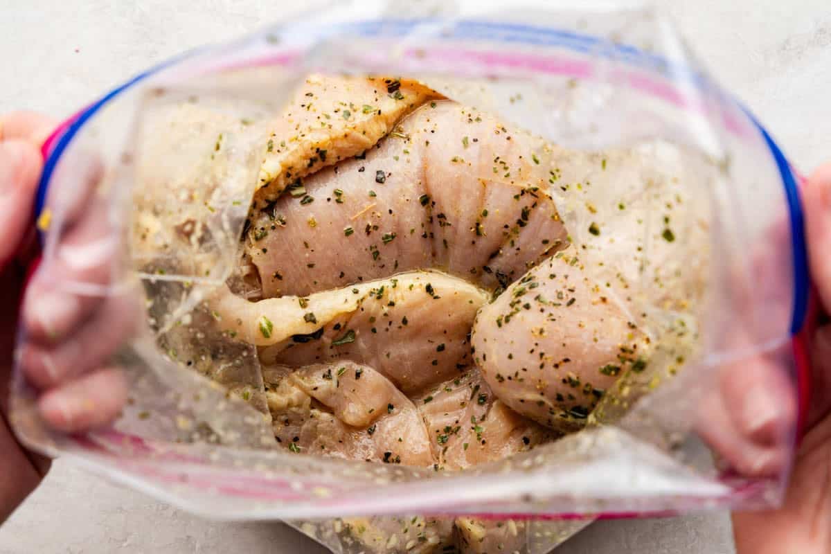 Lemon Herb Baked Chicken Breasts getting marinated in a bag.