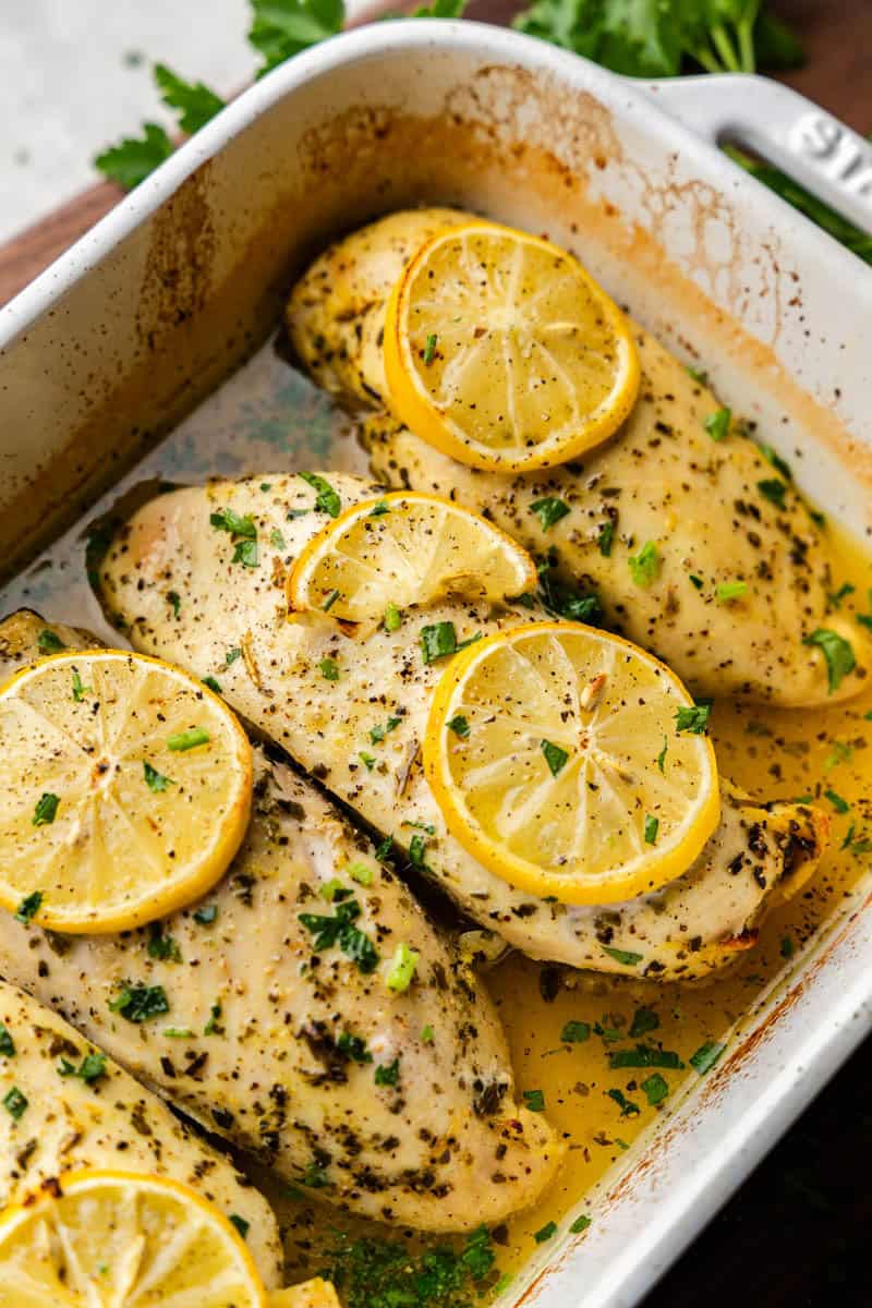 Closeup of Lemon Herb Baked Chicken Breasts in casserole dish.