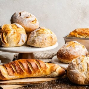 A collection of artisan breads displayed on multiple boards at different heights.