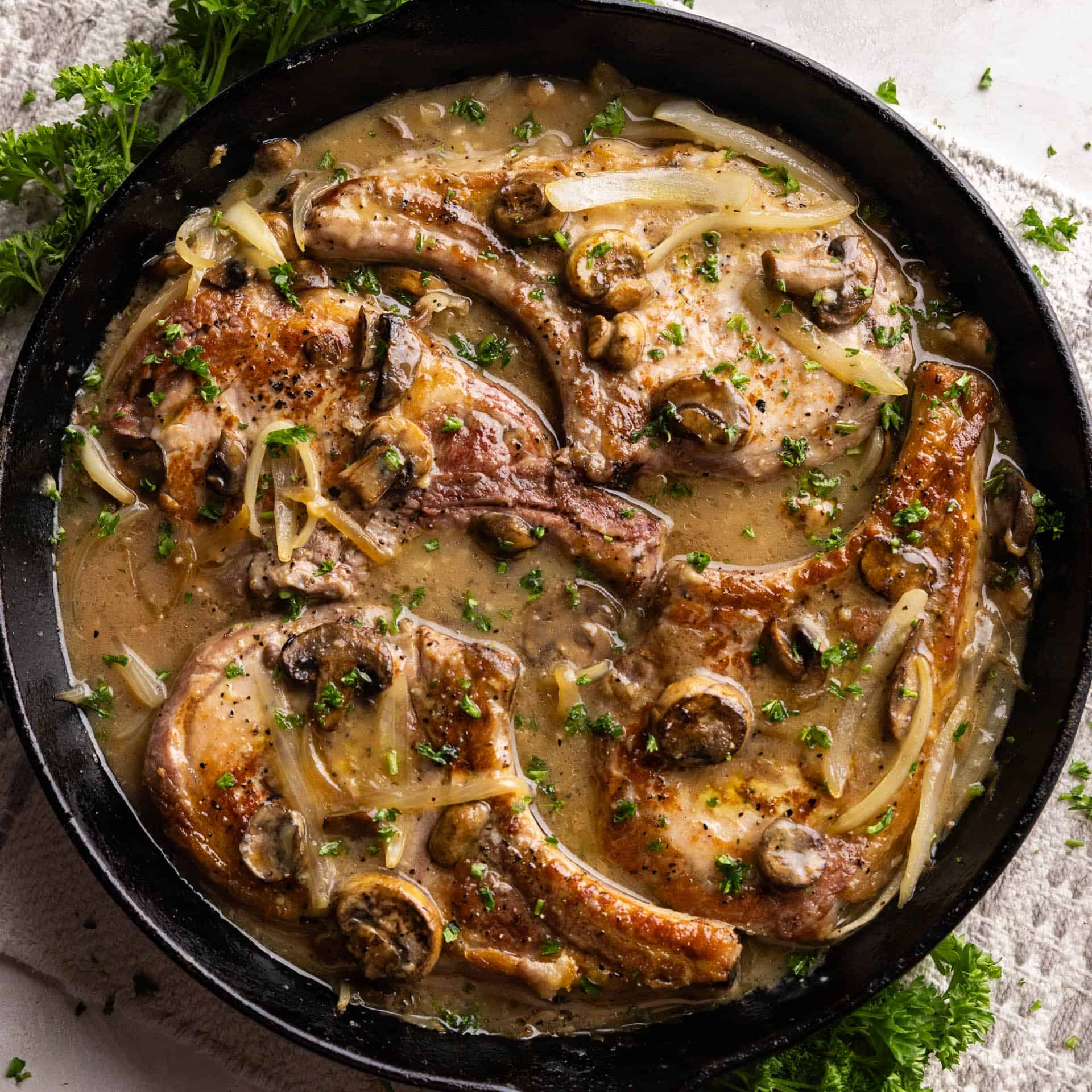 Overhead shot of Smothered Pork Chops in skillet.