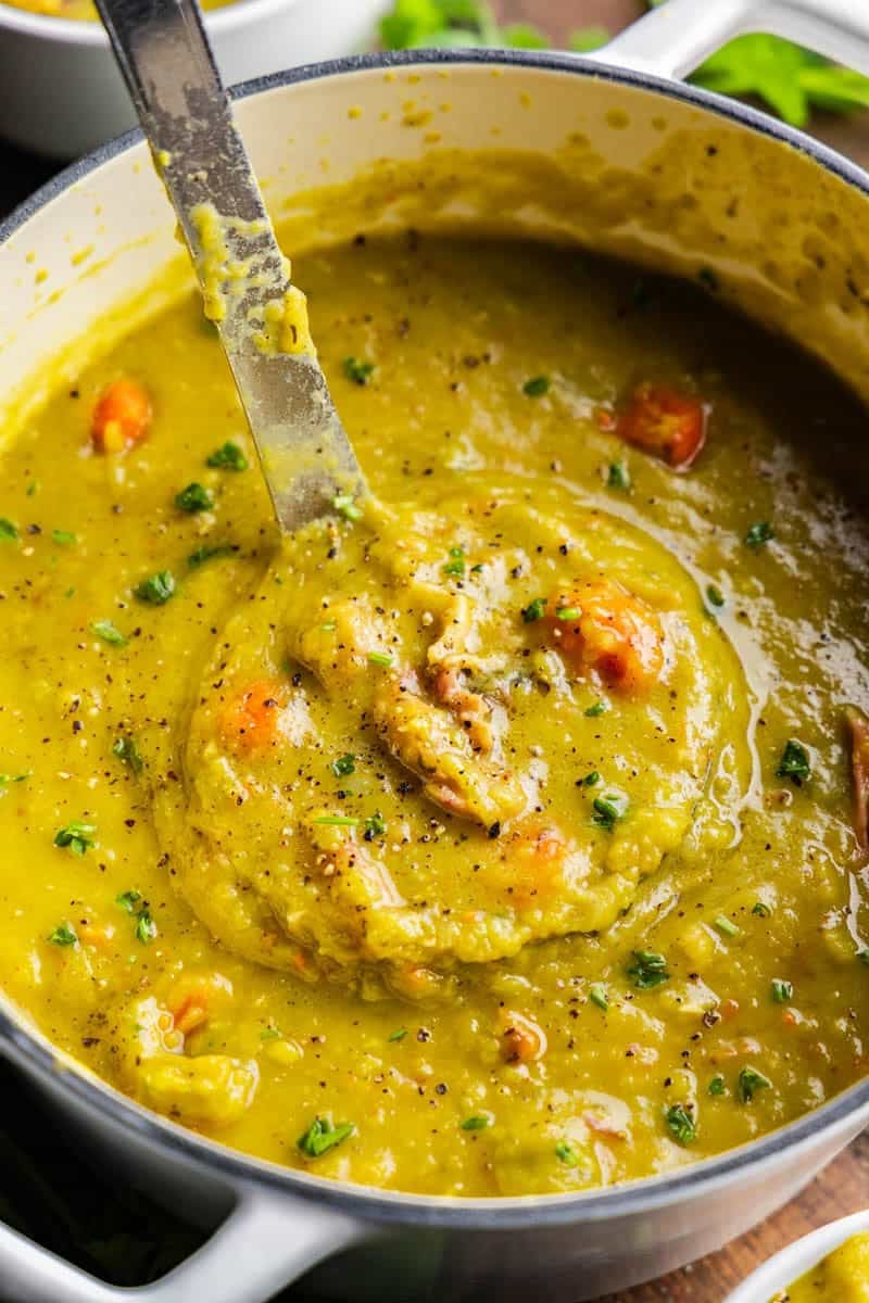 Shot of Split Pea Soup in pot with ladle full.