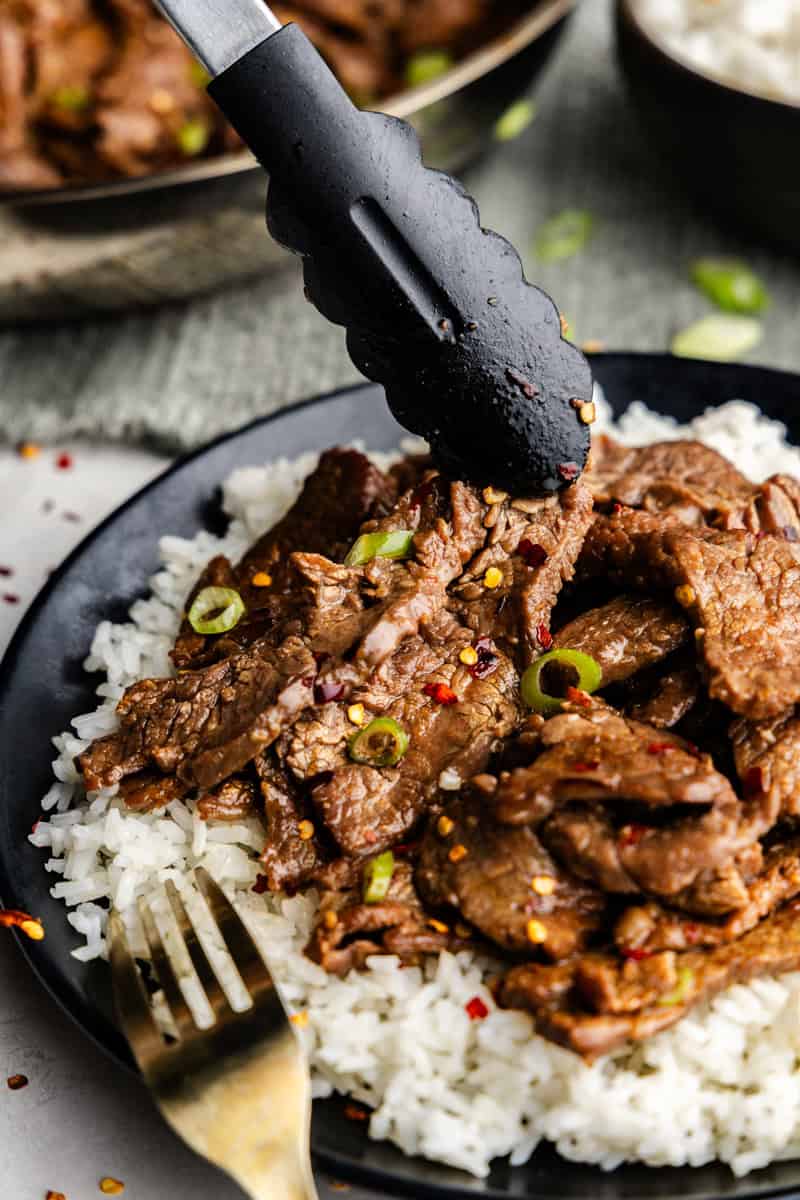 Closeup of 15-Minute Mongolian Beef being picked up by tongs.