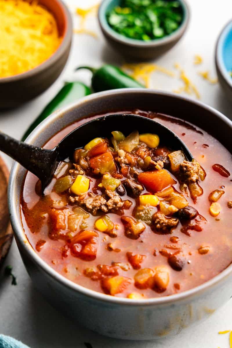 Closeup of a ladle full of 30-Minute Taco Soup.