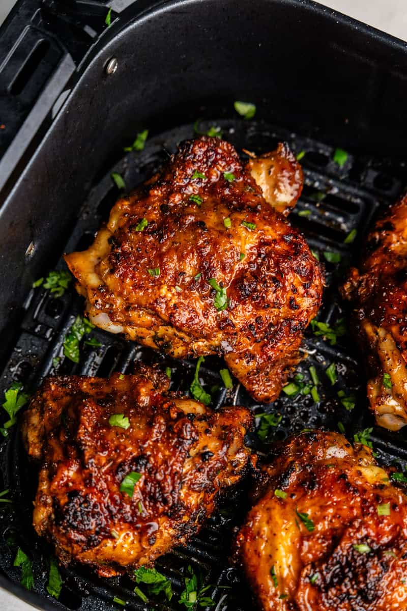 Closeup of chicken thighs in air fryer.