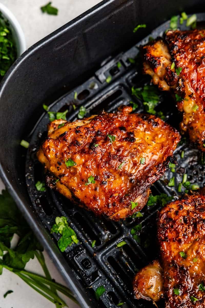 Closeup of chicken thighs in air fryer.