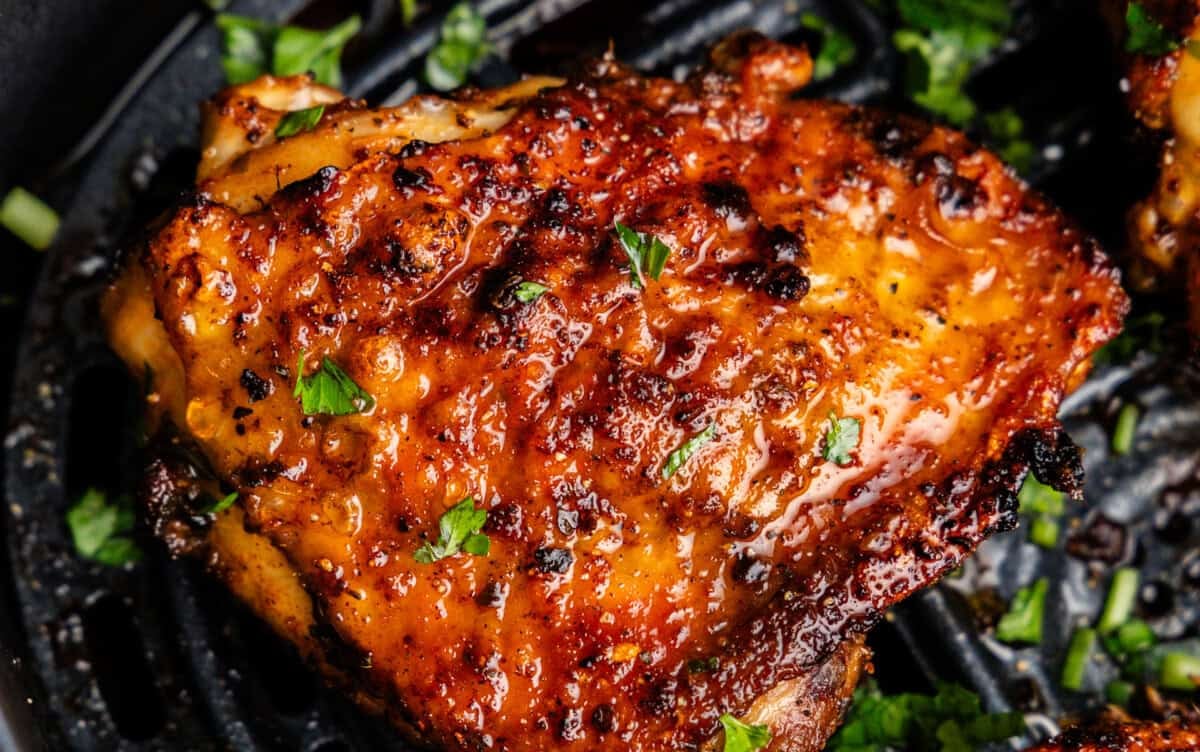 Closeup of chicken thighs in air fryer.