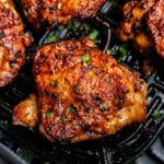 Closeup of chicken thighs in air fryer.