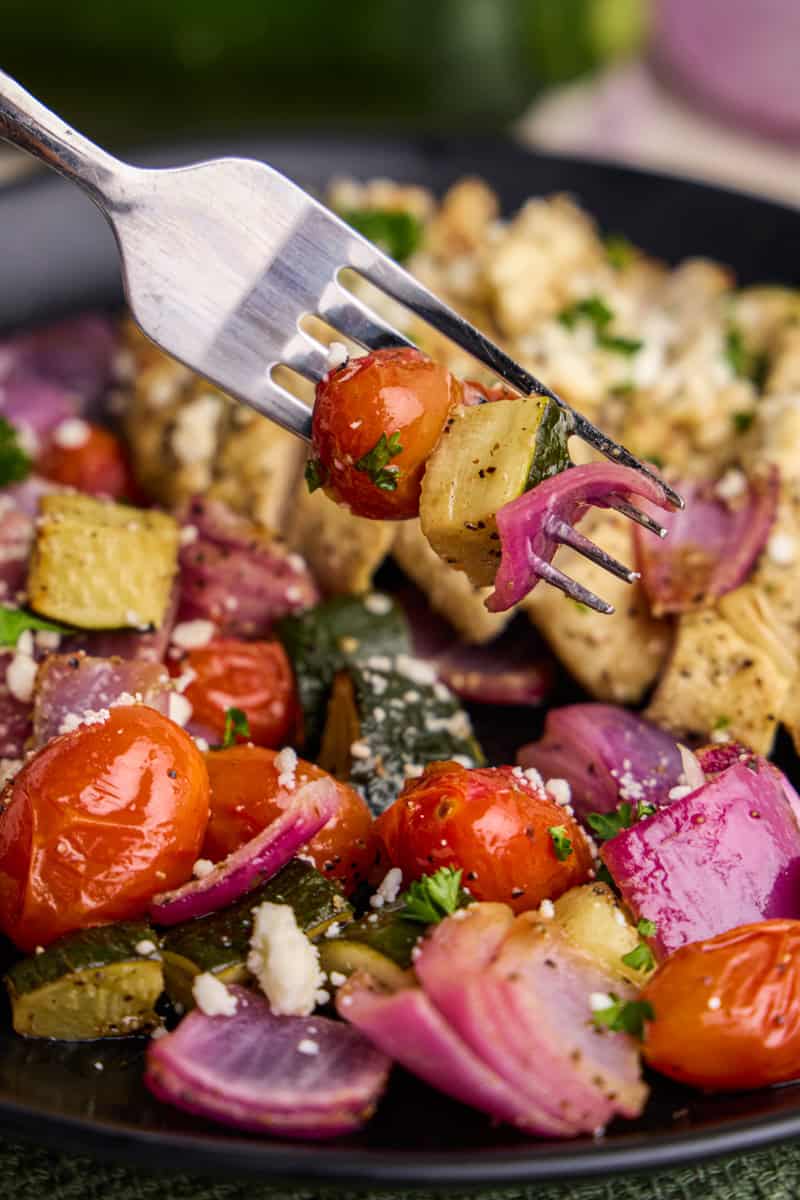 Close up view of a forkful of veggies from Air Fryer Greek Chicken & Veggies.