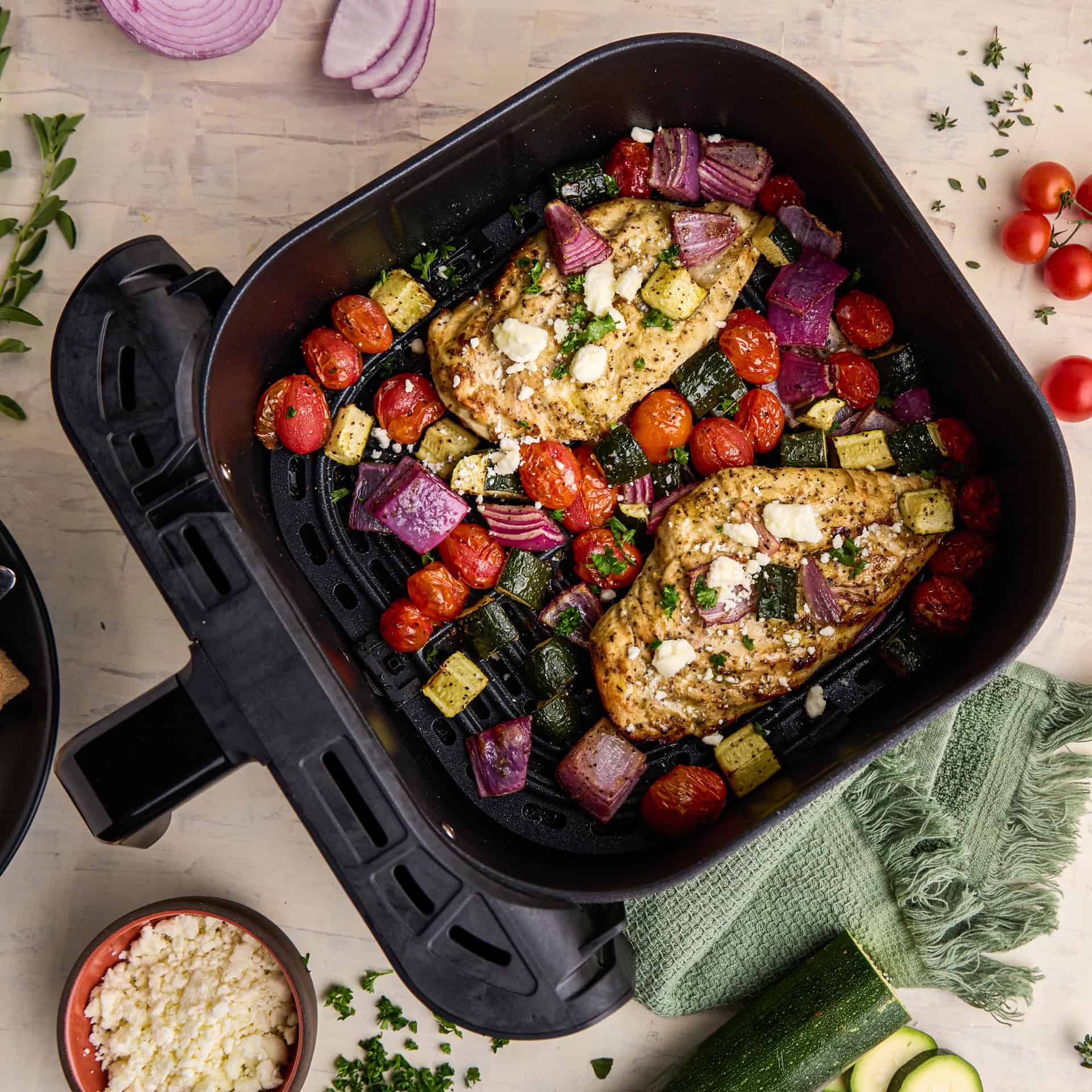 Air Fryer Greek Chicken & Veggies in the airfryer pot.