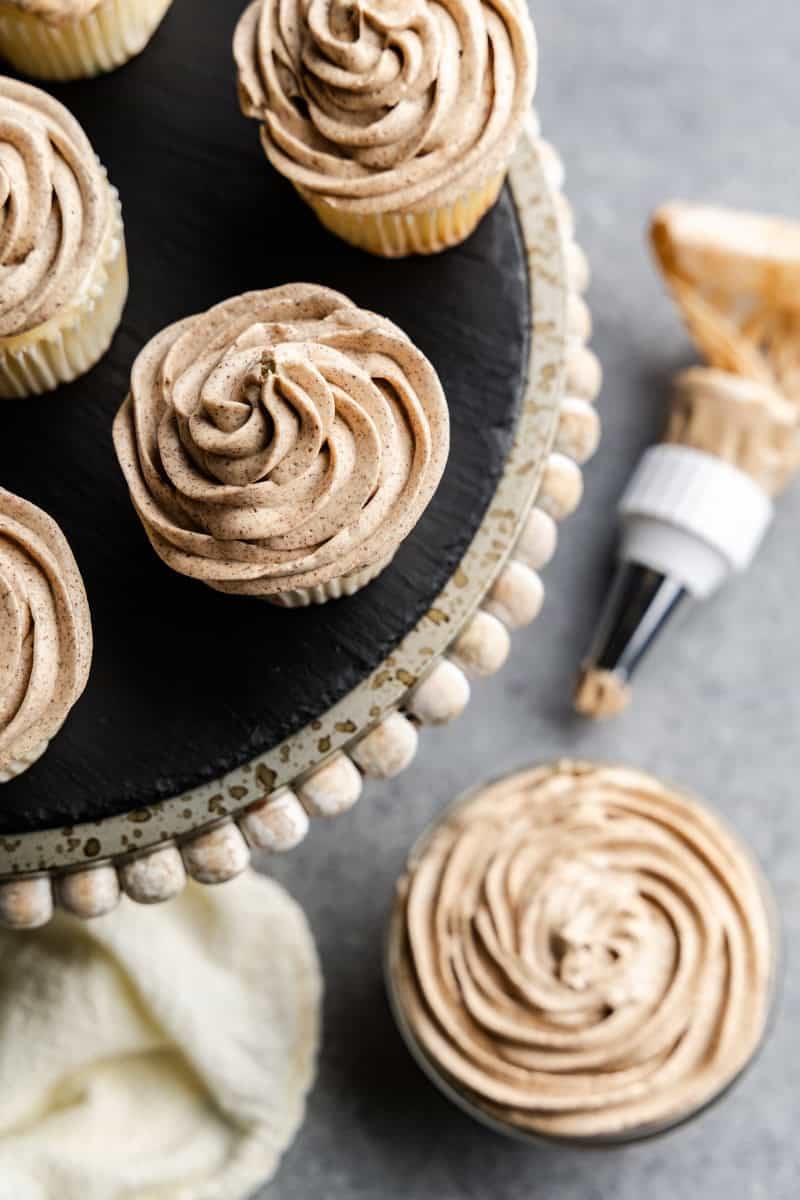 Closeup of cupcakes frosted with browned butter frosting on a cake stand.