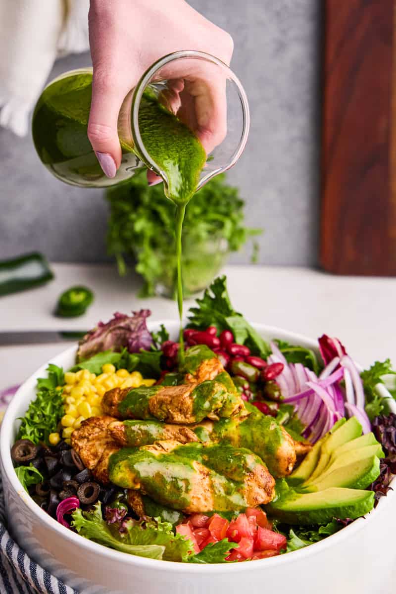 Cilantro-Lime Vinaigrette being poured over Chicken Taco Salad.