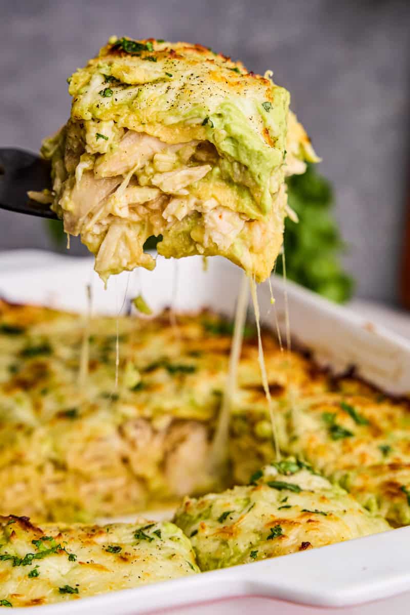Creamy Chicken Enchilada Casserole being dished out with a spatula.