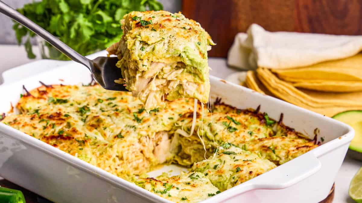 Creamy Chicken Enchilada Casserole being dished out with a spatula.