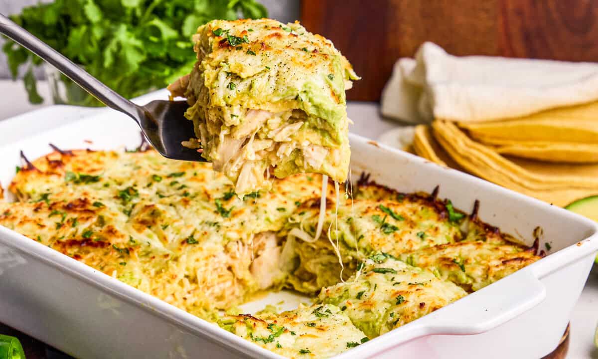 Creamy Chicken Enchilada Casserole being dished out with a spatula.